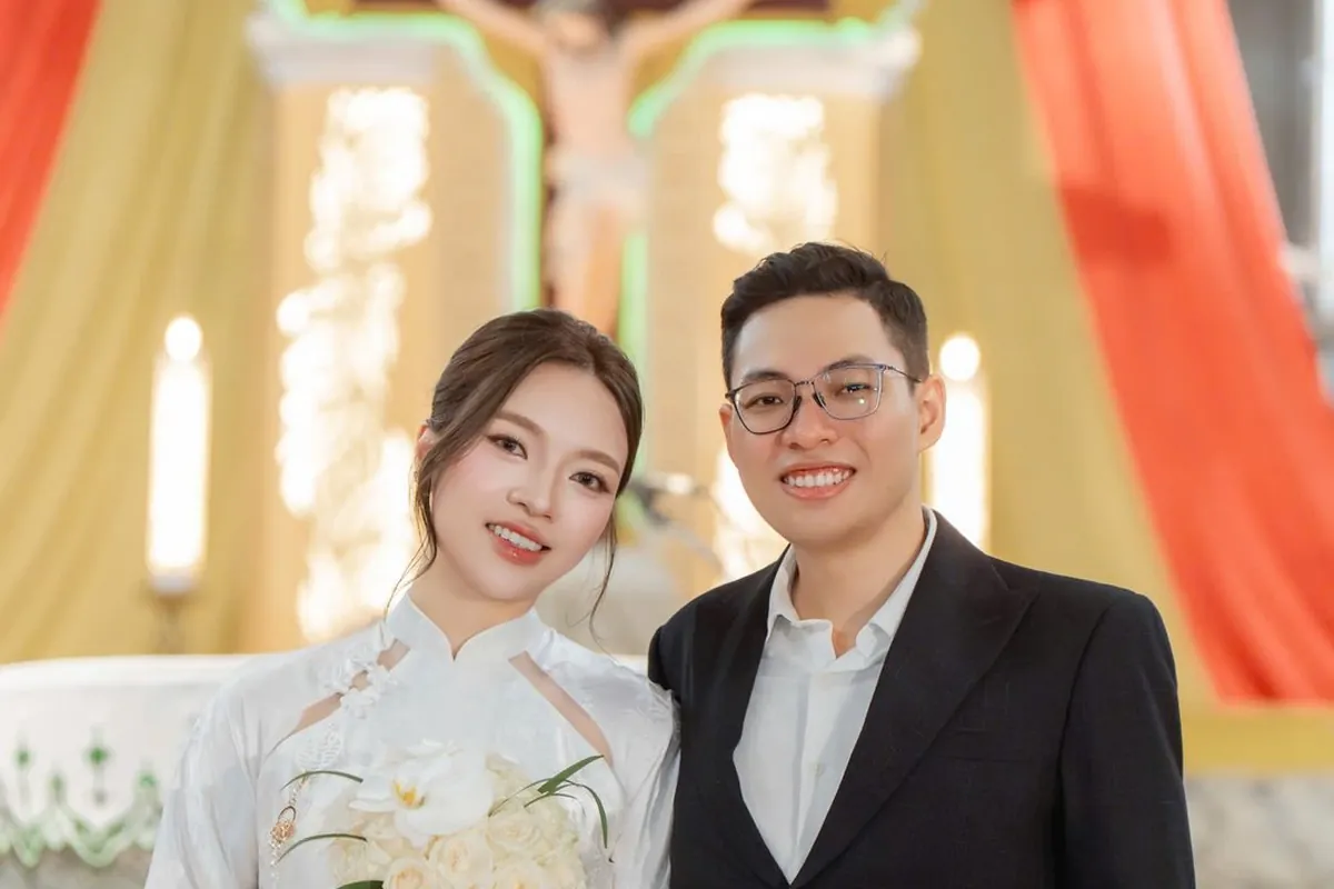Cô dâu áo dài trắng và chú rể vest đen trong lễ cưới ở nhà thờ