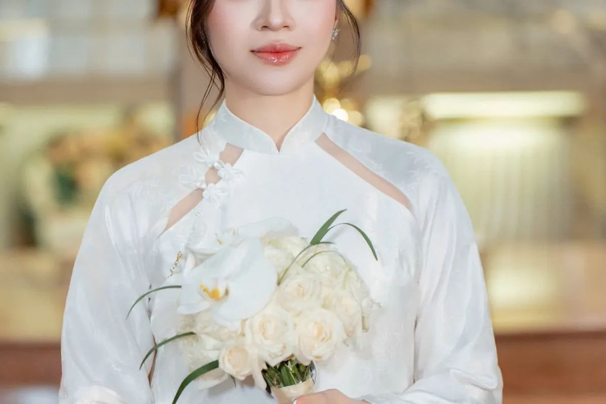 Cô dâu áo dài trắng cầm bó hoa lan