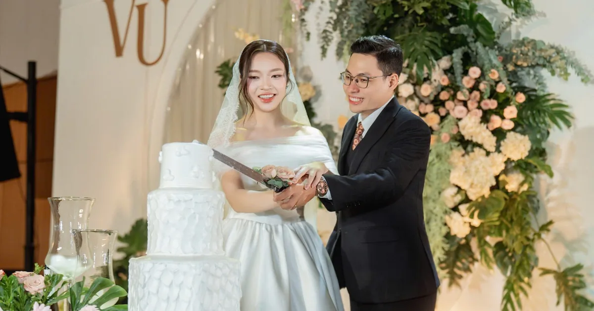 Cô dâu chú rể cùng cắt bánh cưới trong tiệc