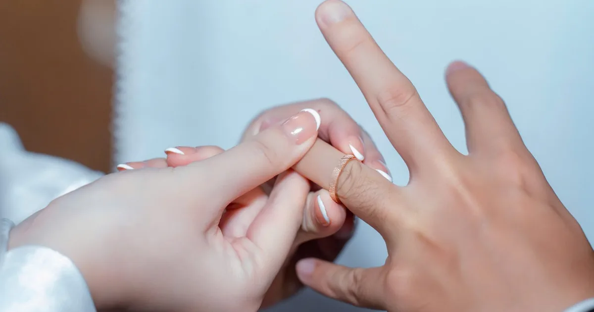 Đôi tay cô dâu chú rể đeo nhẫn cưới
